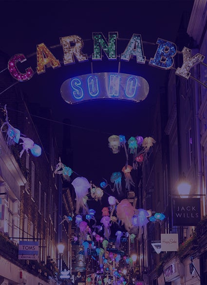 A glowing sign "Carnaby" above a street.