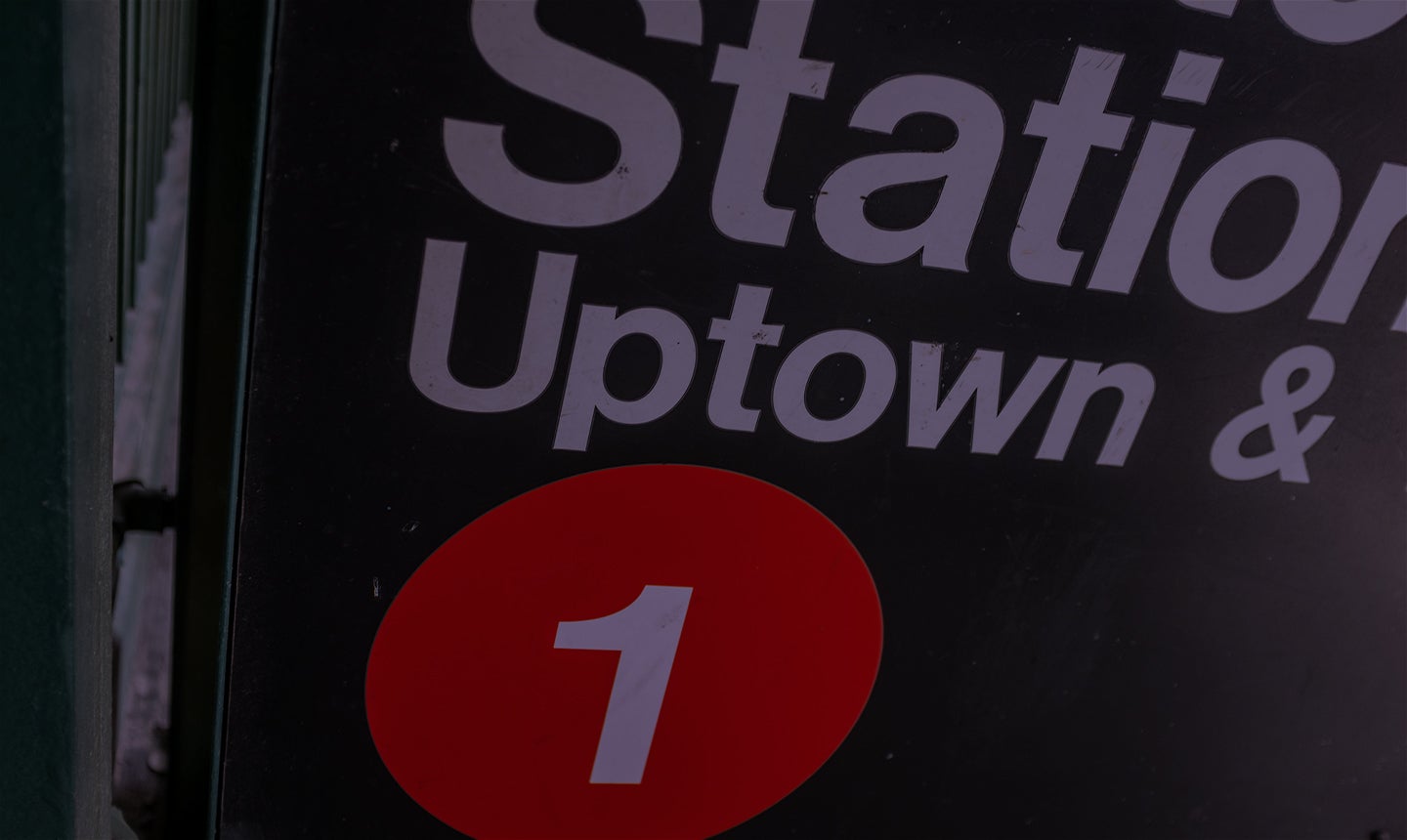 A subway station sign calling out the Uptown stop.
