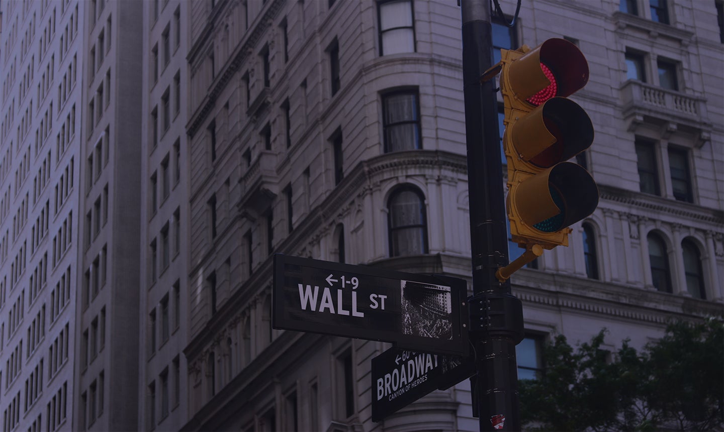 A stoplight at the corner of Broadway and Wall street