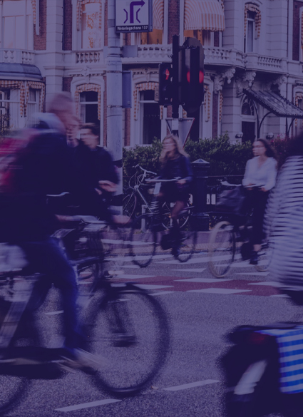 People riding bikes on a busy street.