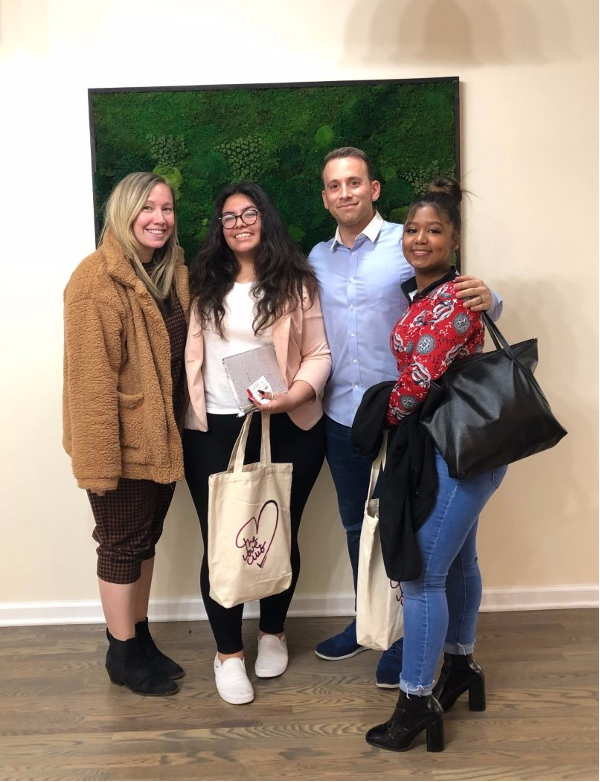 Group shot of four people standing in front of a green painting