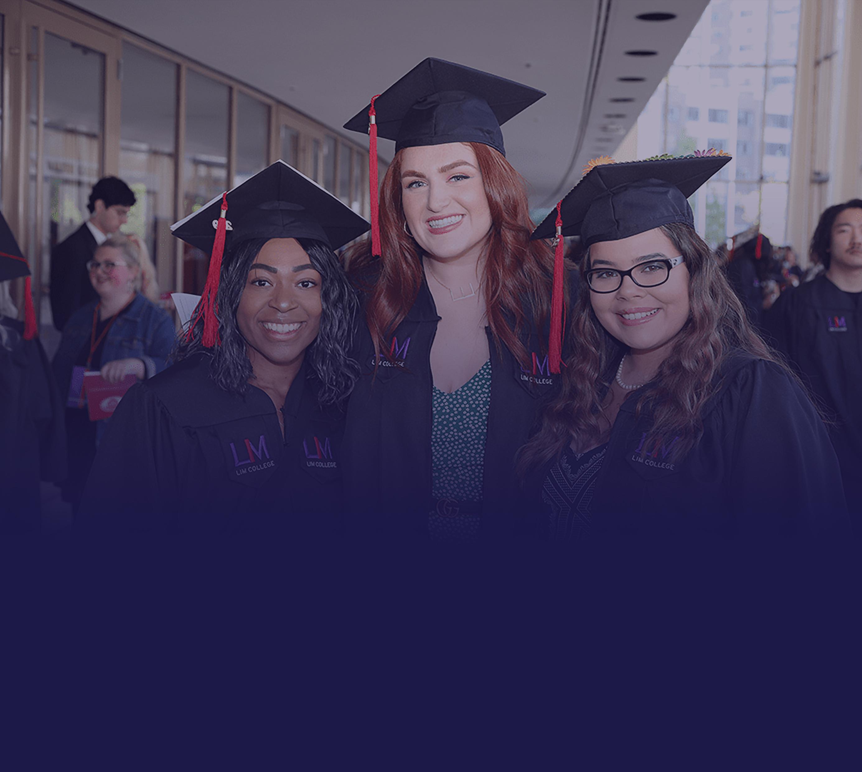 Three girls in caps and gowns smiling.