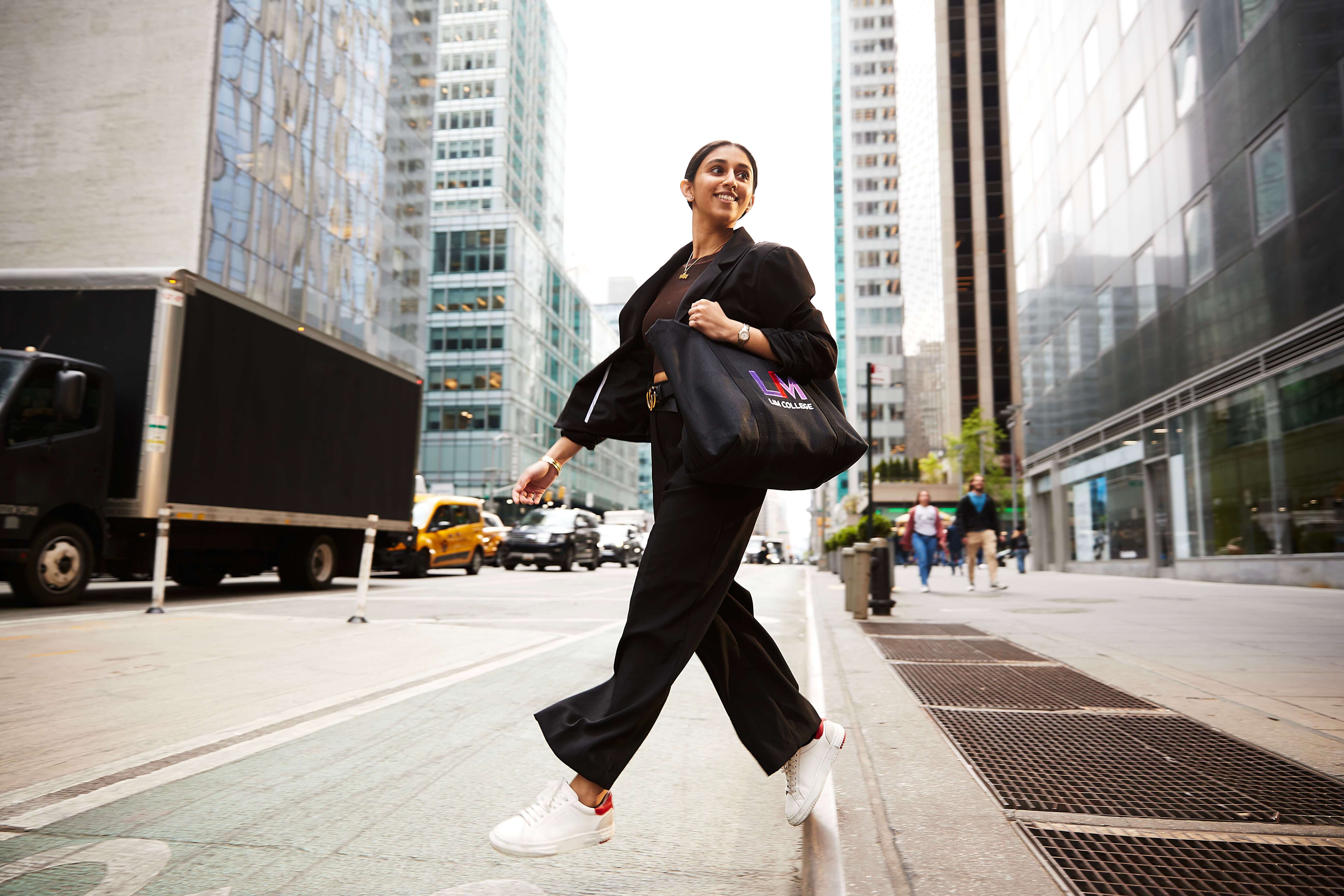 woman with LIM tote bag crossing street