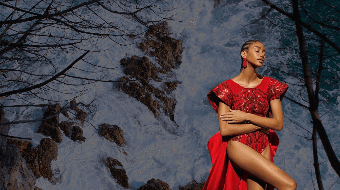 model in a red dress with water flowing behind her