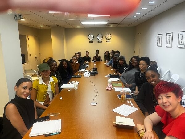 students seated around long boardroom table, college club meeting