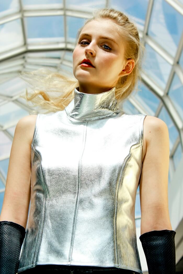 blonde woman, sleeveless silver top, black gloves.