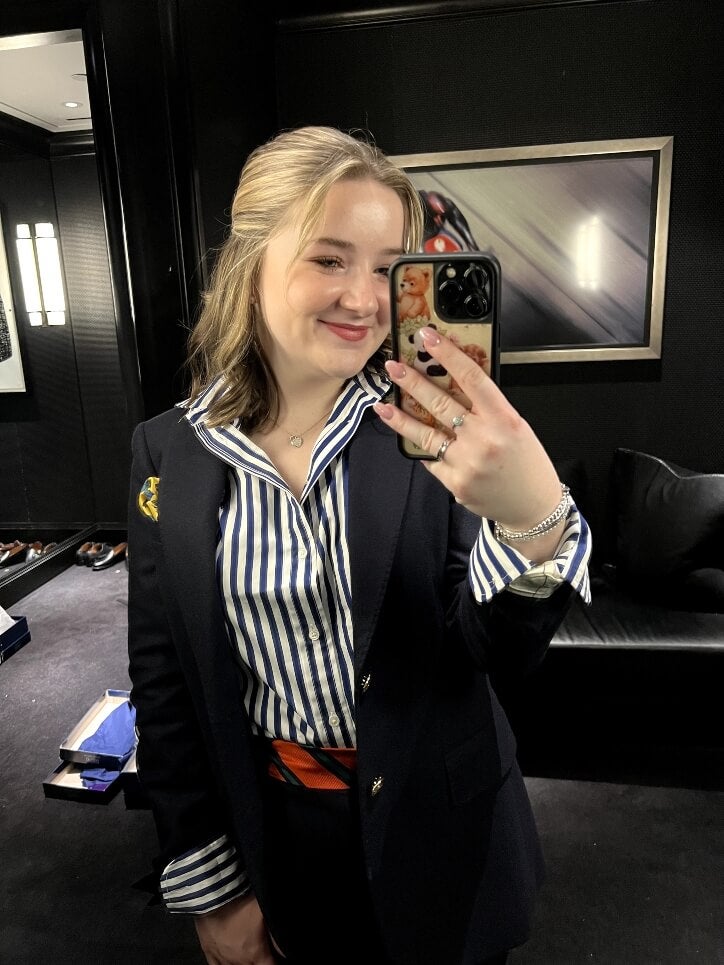 Molly selfie-ing, suited, striped shirt, internship office