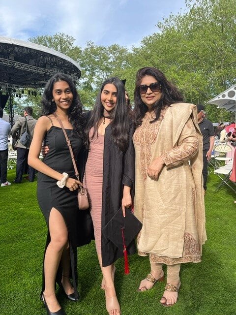 Three women on the grass at LIM College 2022 graduation ceremony