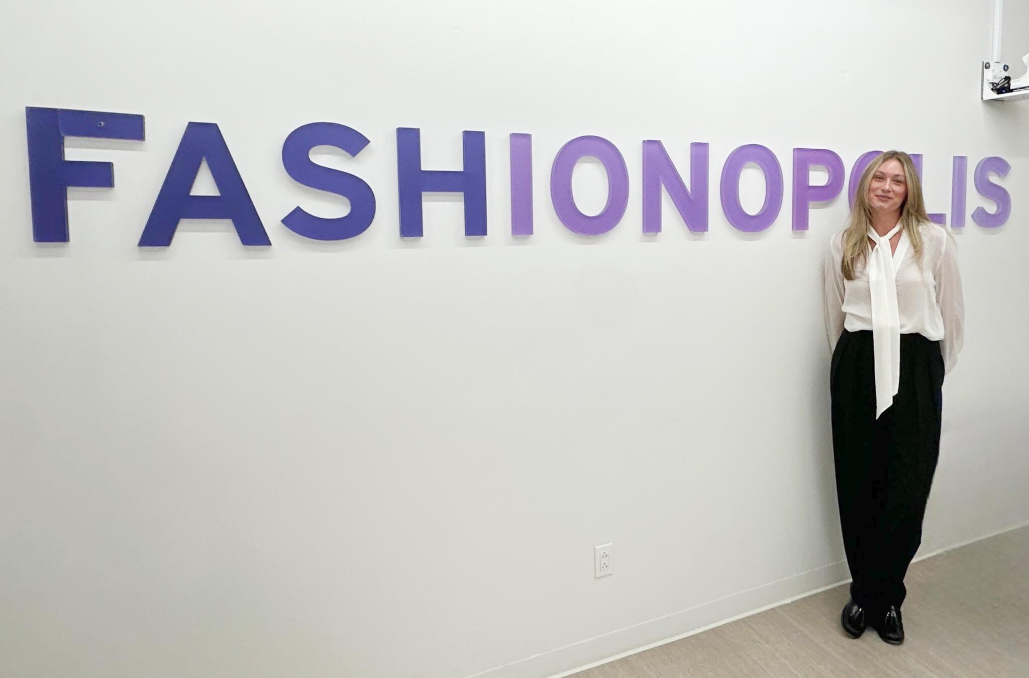 woman, long blonde hair, white shirt, FashionOpolis sign