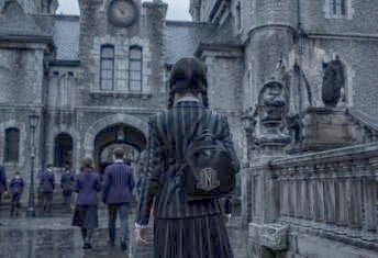Wednesday Addams attire, hair, young woman walks away toward gothic building