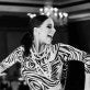 Black and white photo, young woman in ballroom dance studio, smiling and dancing