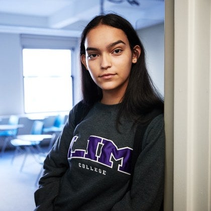 student in classroom doorway wearing LIM shirt