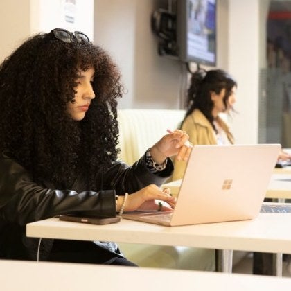 female student with dark hair on laptop