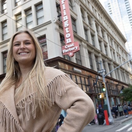 woman smiling at camera outside a Burlington Coat Factory store