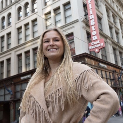 woman smiling at camera outside a Burlington Coat Factory store