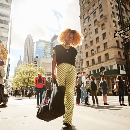 student looking at the camera on Fifth Ave with an LIM tote