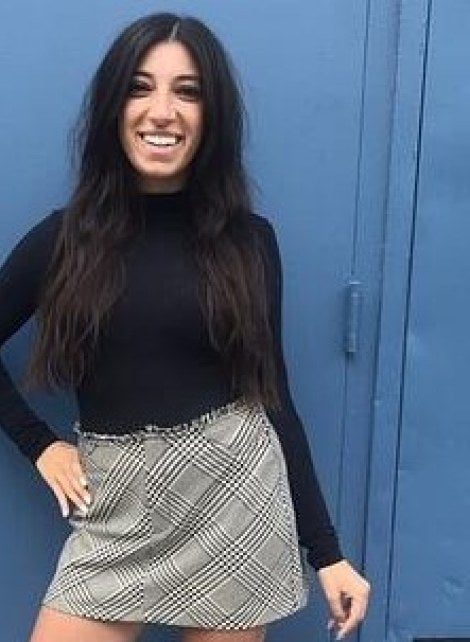 Person standing in front of blue wall