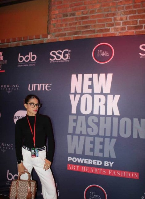 girl posing in front of NYFW sign