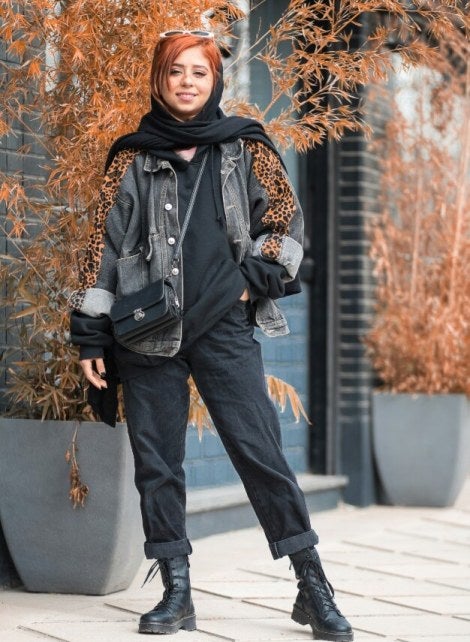 model in black clothing, red hair, decorative plant potters, cement paving stones