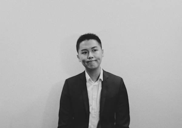 grad student standing against white background, black and white photo