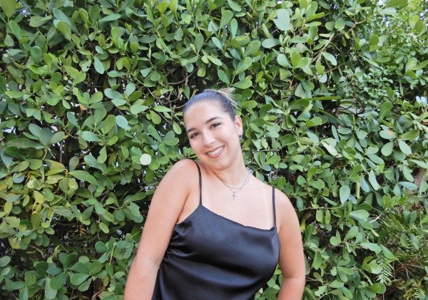 girl in front of shrubs