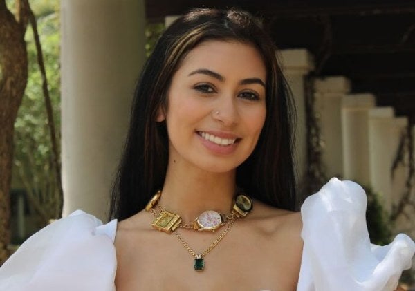 young woman, white formal dress, necklace with thick charms, outdoor environment