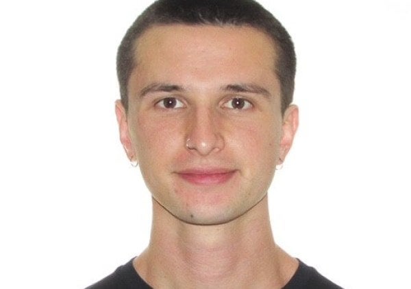 young man, dark-hair buzzcut, black shirt, medium close-up
