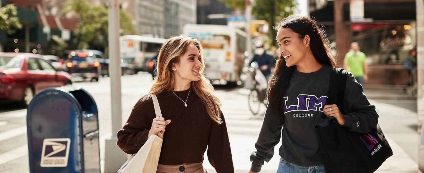 Two LIM College students walking down the sidewalk in the city