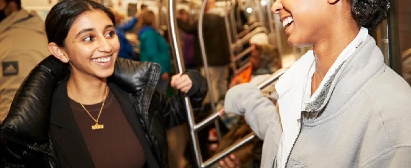 two young women riding NYC subway