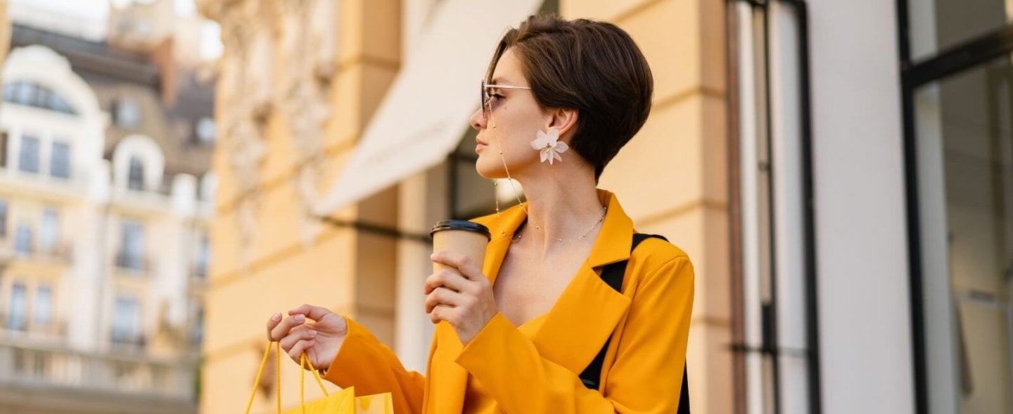 woman in yellow coat, yellow shopping bag, coffee, luxury shopping environment