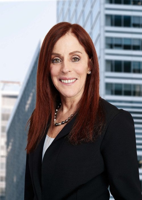 woman in black and white suit in front of skyline