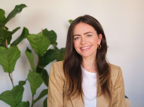 photo of a woman sitting in front of plant