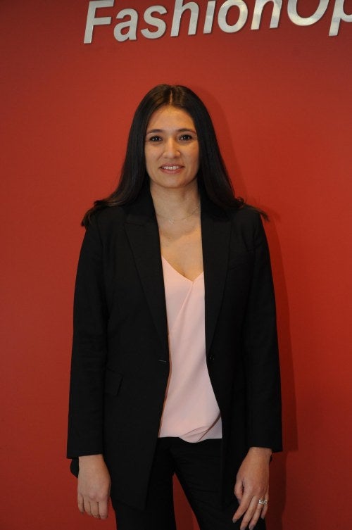 photo of a woman standing in front of red wall