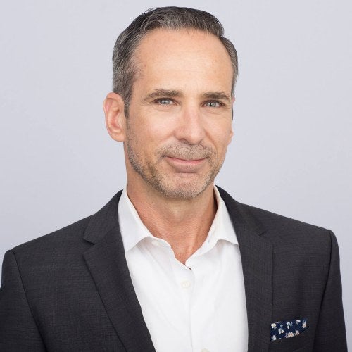 headshot of a man in front of white background