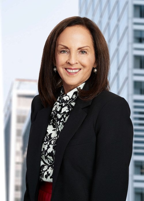 woman in black and white suit in front of skyline