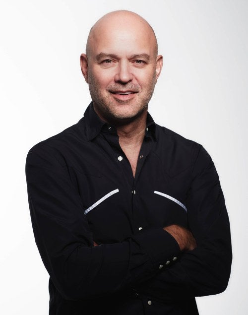 photo of a man with his arms crossed posing in front of white background