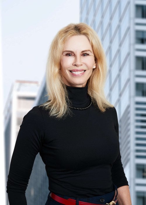 woman in black turtleneck with red belt in front of skyline