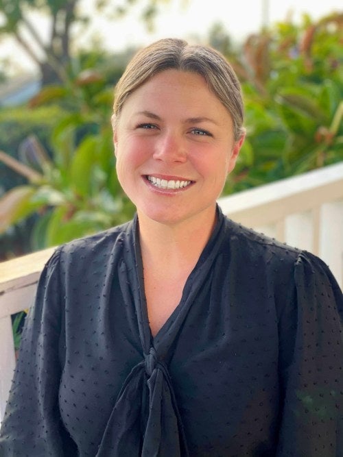 photo of a woman smiling with plants in the background