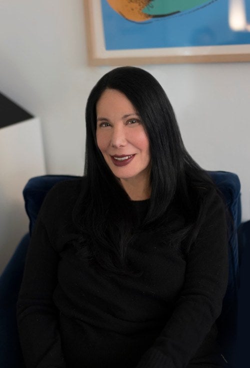 photo of a woman wearing all black sitting in a chair 