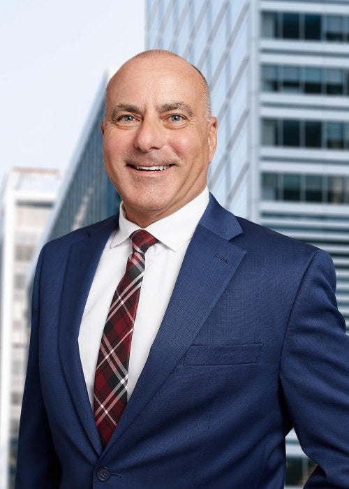 man blue suit in front of skyline