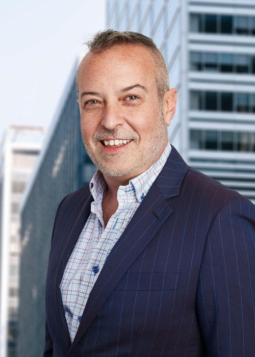 man in blue suit without tie smiling at camera