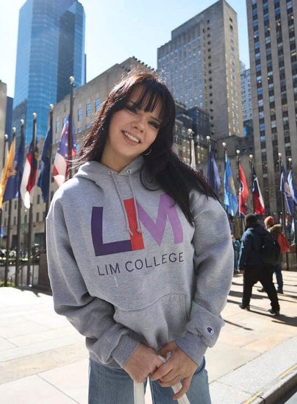 dark-haired young woman in LIM College hoodie, standing outdoors in Rockefeller Plaza