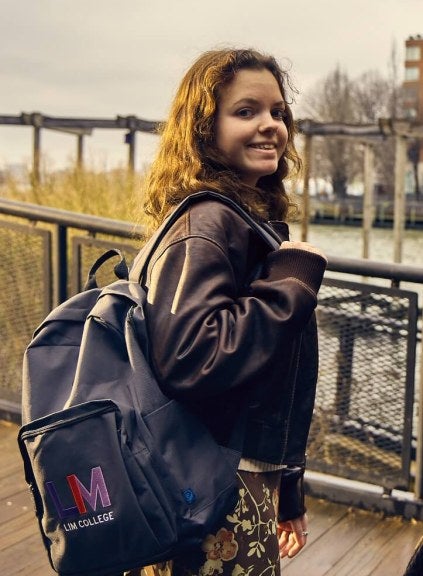 young woman, long brown hair, LIM College backpack, leather coat, South Cove Park