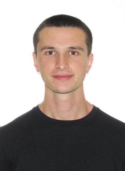 young man, dark-hair buzzcut, black shirt, medium close-up