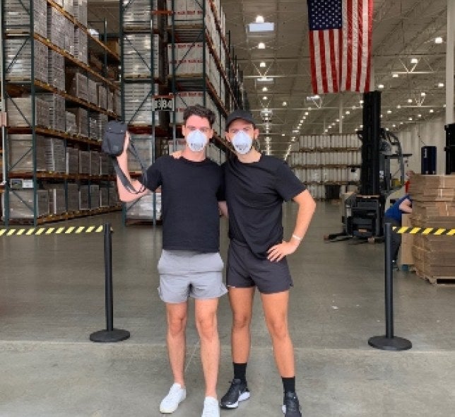 Anthony and Baylen holding the PPE product they developed.