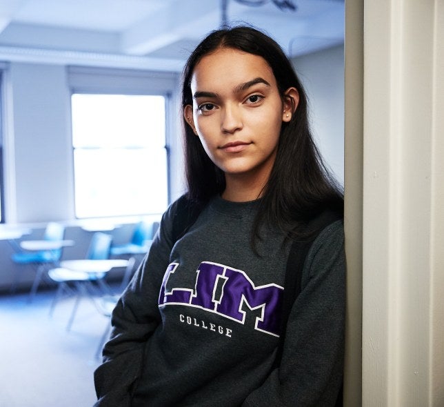 student in classroom doorway wearing LIM shirt