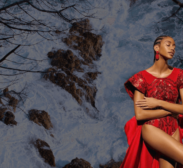 model in a red dress with water flowing behind her