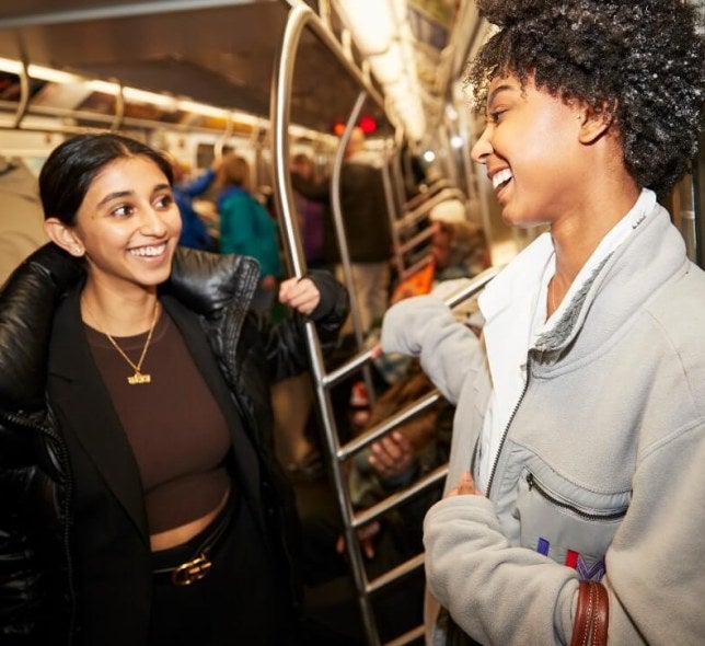 two young women riding NYC subway