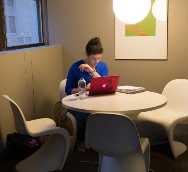 woman on laptop, blue shirt, water bottle