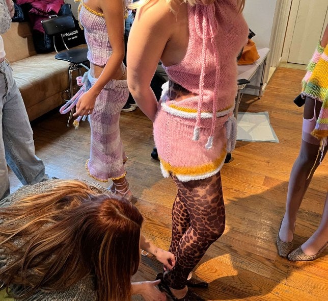 Girl helping model dress